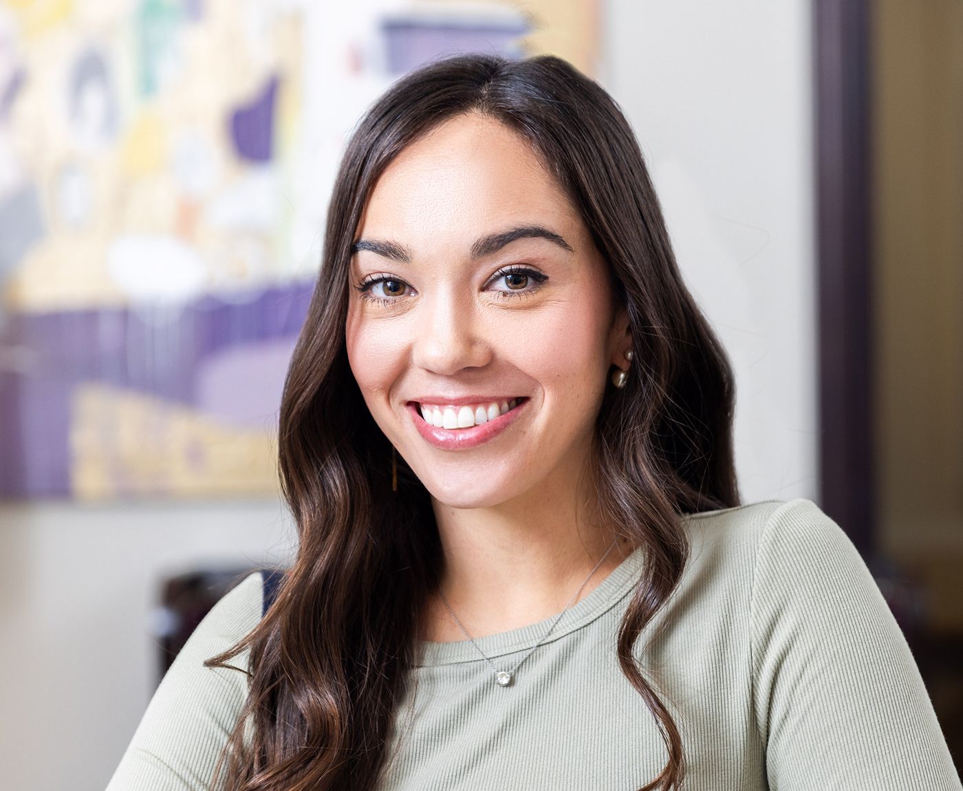 Smiling young woman with long dark hair.