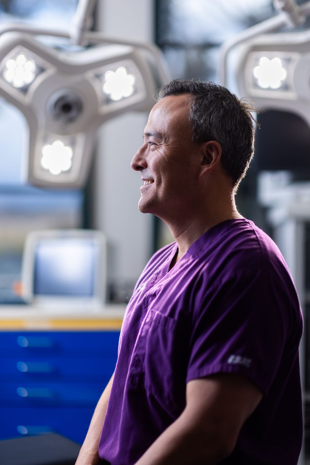 Medical professional smiling in a clinical setting.