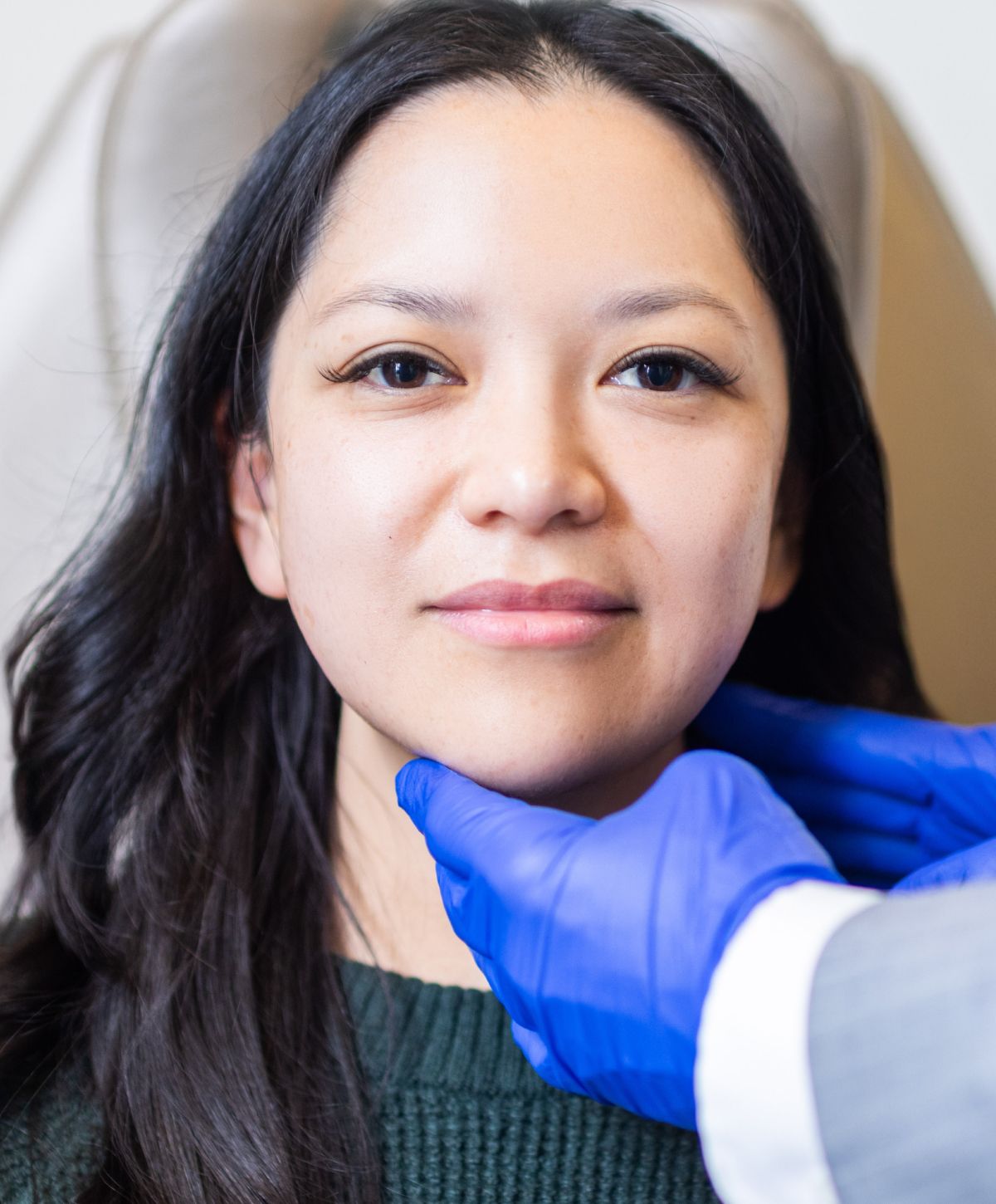 Woman with long hair receiving facial treatment.