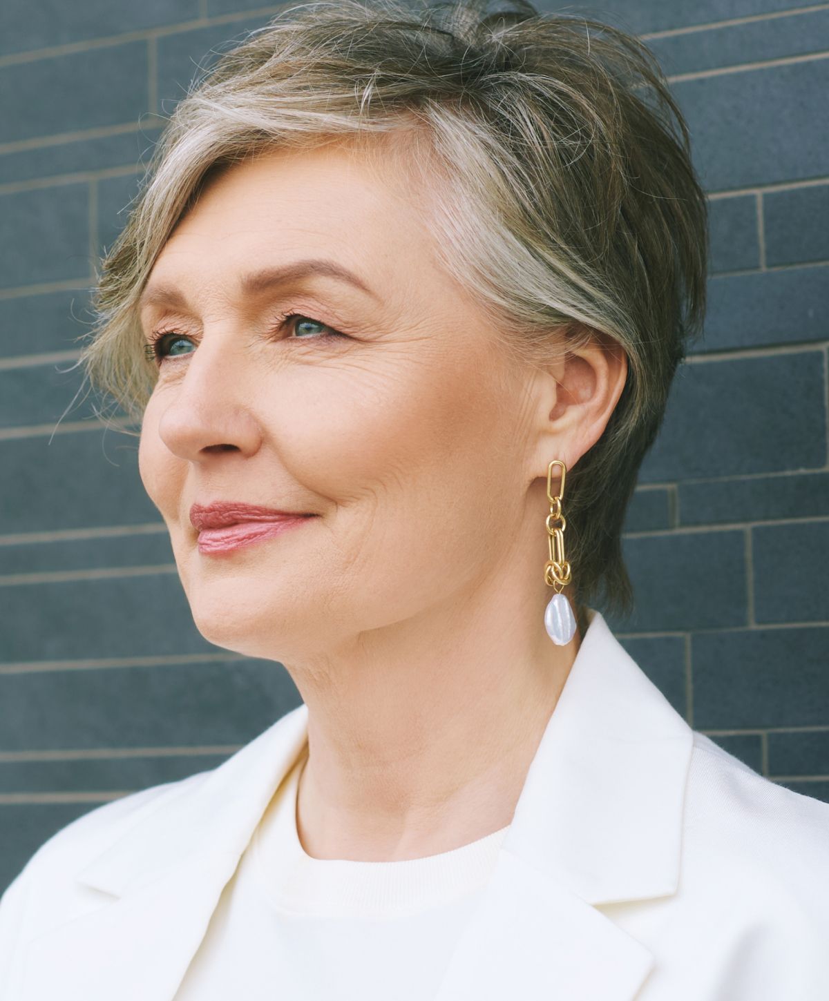Woman with short hair wearing statement earrings.