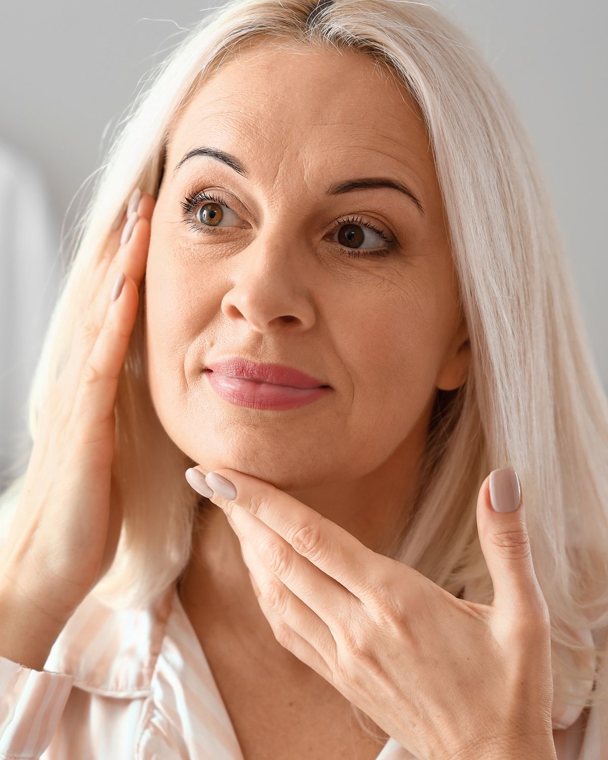Woman examining her face in natural light.