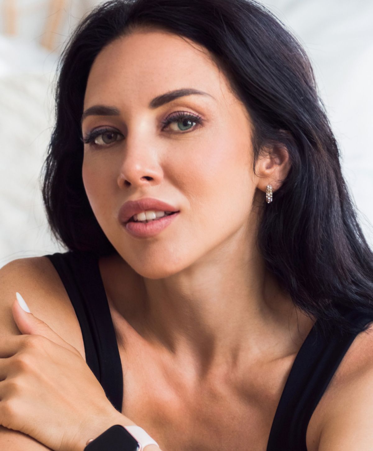 San Diego frown line treatment model with dark hair and earrings.