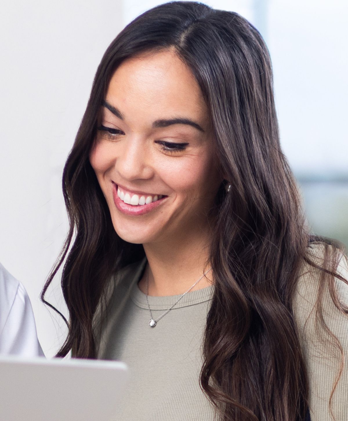 Smiling woman looking at laptop screen.