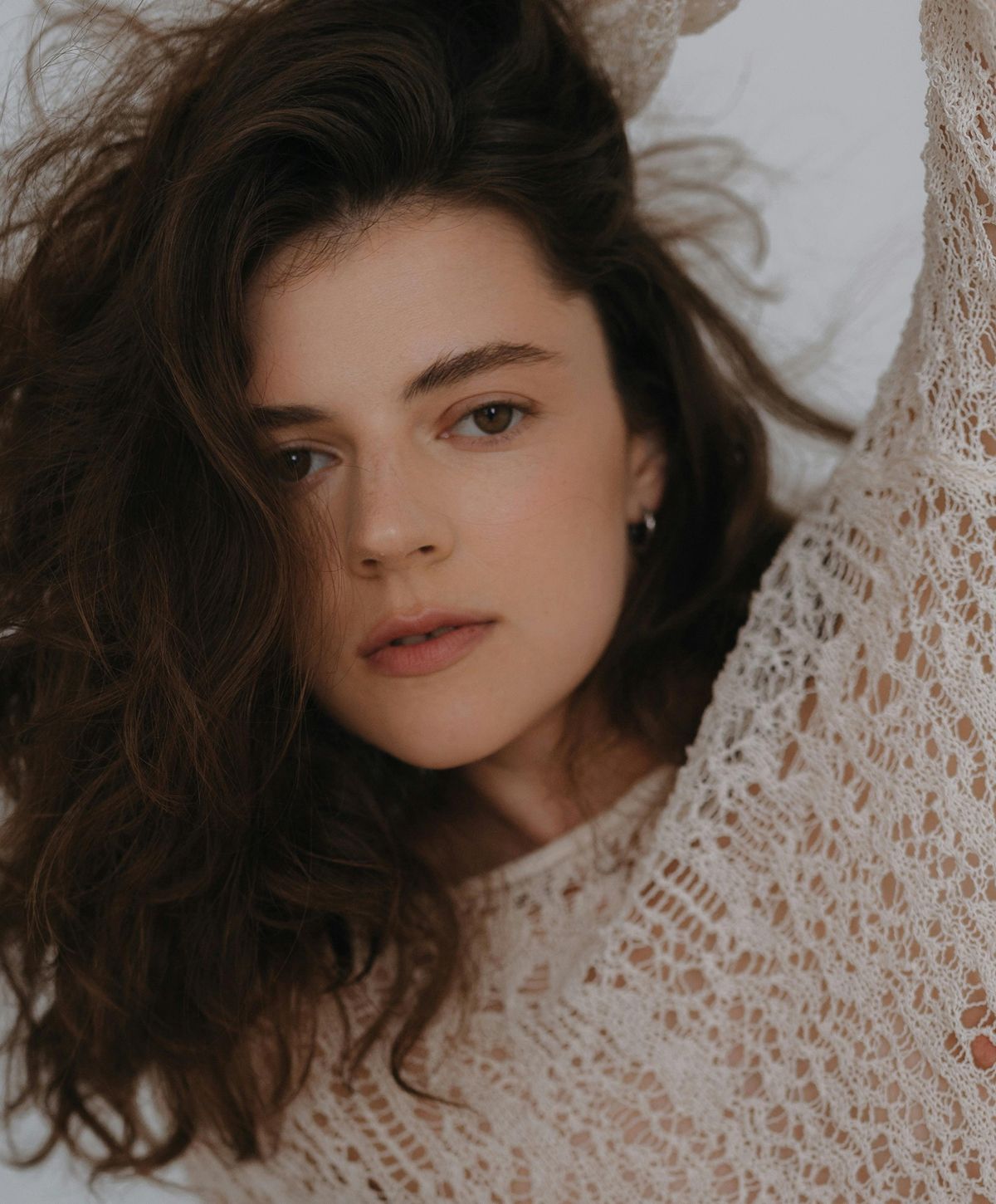 Woman with curly hair in knit sweater.