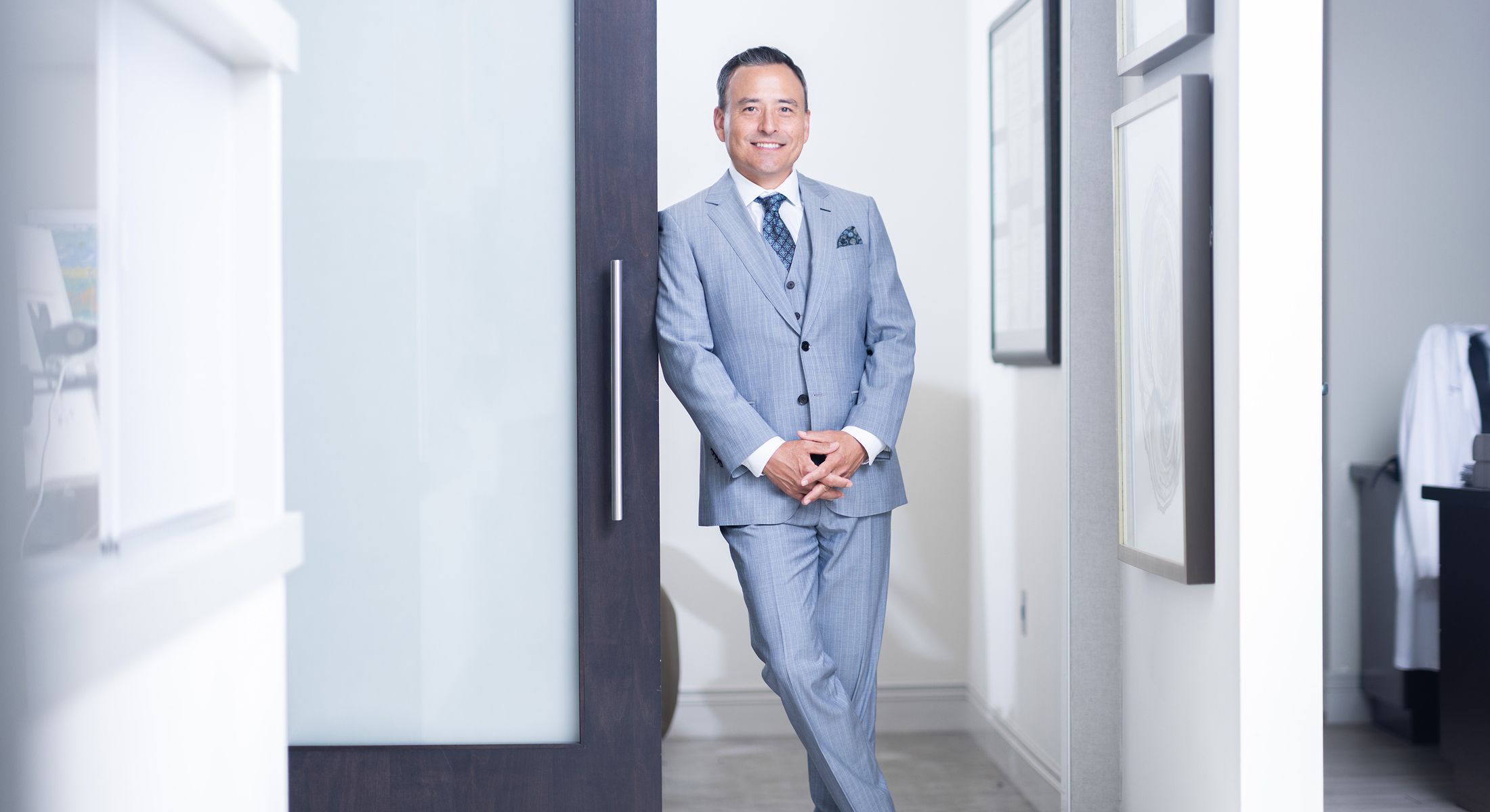 Man in a suit standing by a door.