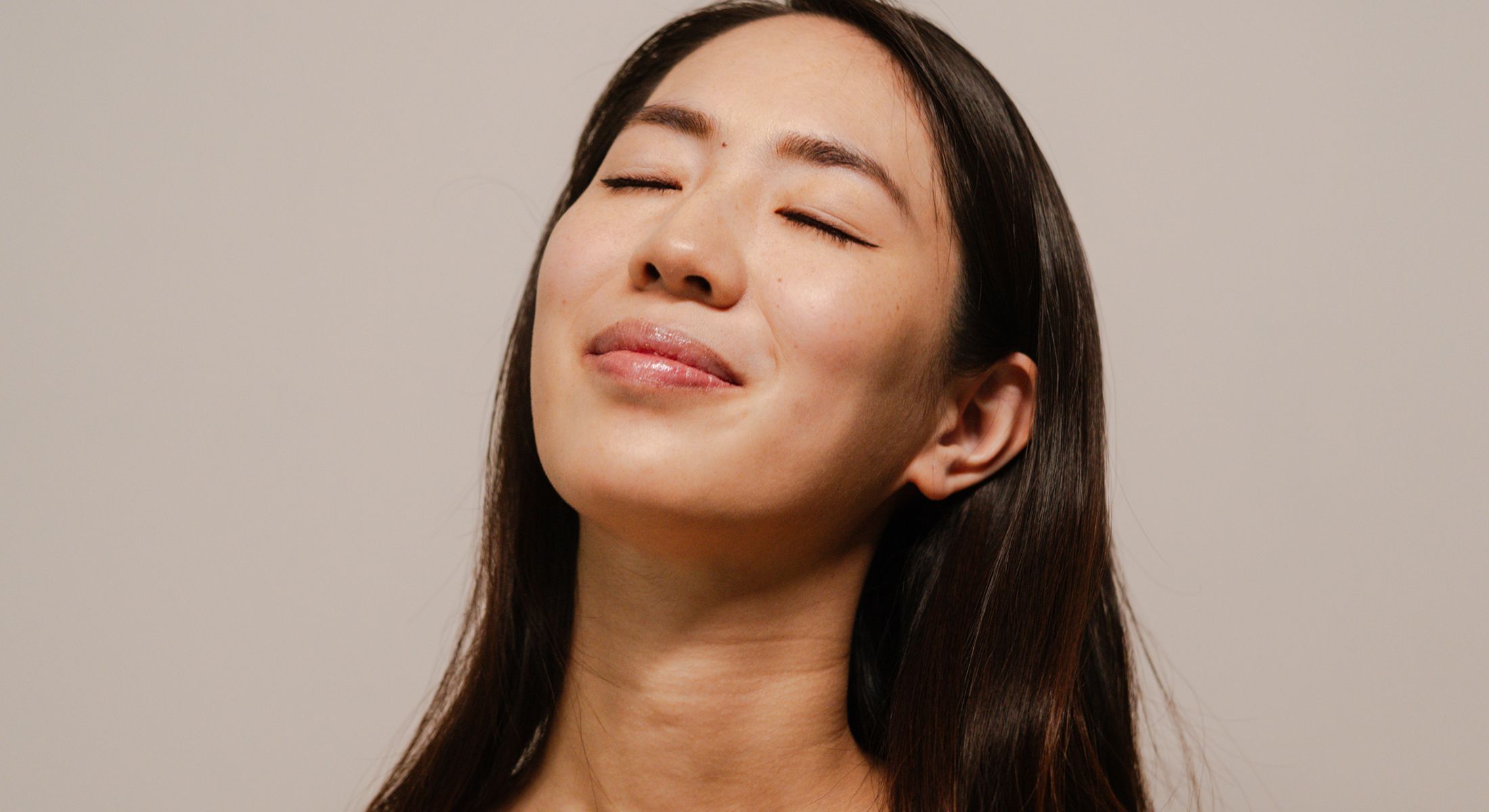 Woman with eyes closed, smiling peacefully.