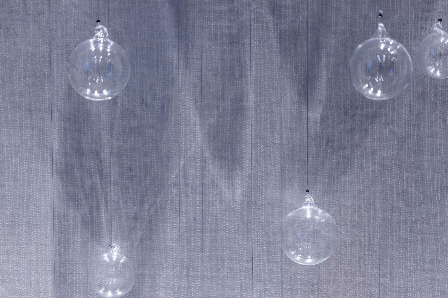 Hanging glass orbs against a textured background.