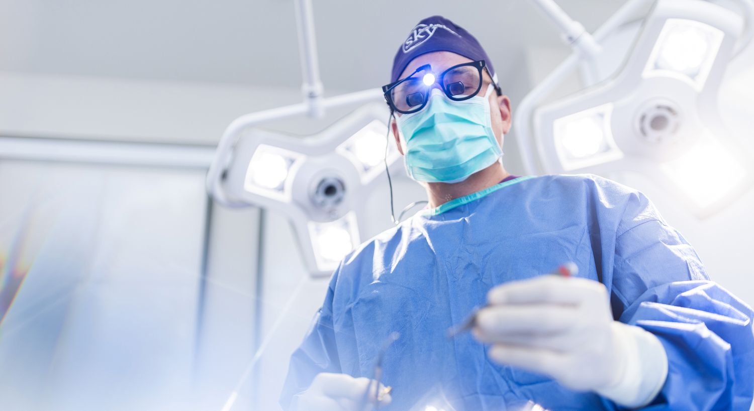 Surgeon preparing for a procedure in an operating room.